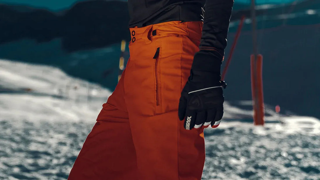 Waterproof orange snow pants for beginners, designed for performance and comfort.