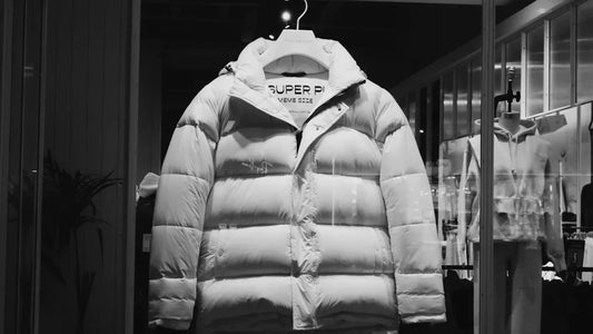 White puffer jacket on display in a shop window.