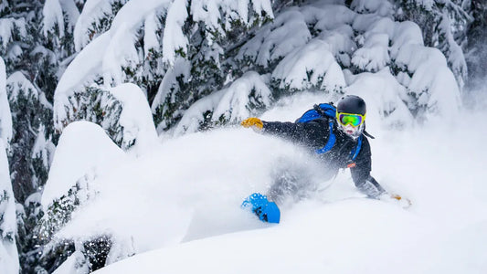 Snowboarder in full gear carving through fresh snow