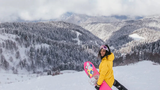 Yellow snowboard jacket and pants with a stylish pink snowboard