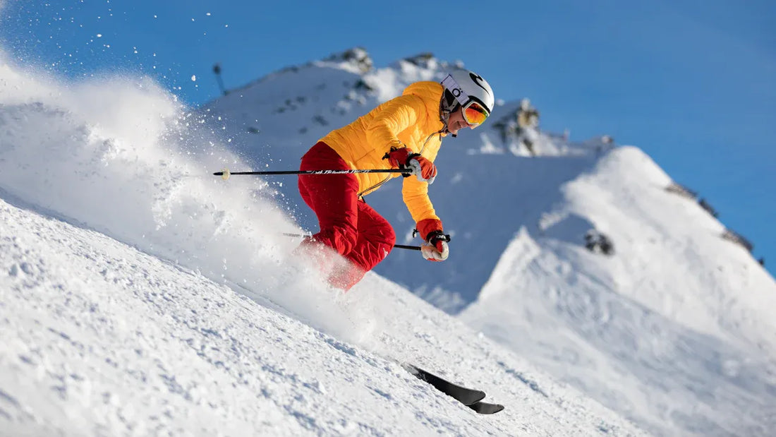 Skiing down the slope in red baggy ski pants and yellow jacket.