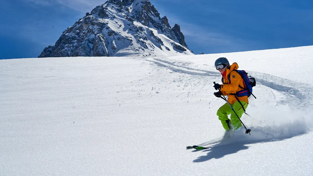 Skiing with bright orange jacket and green baggy snow pants