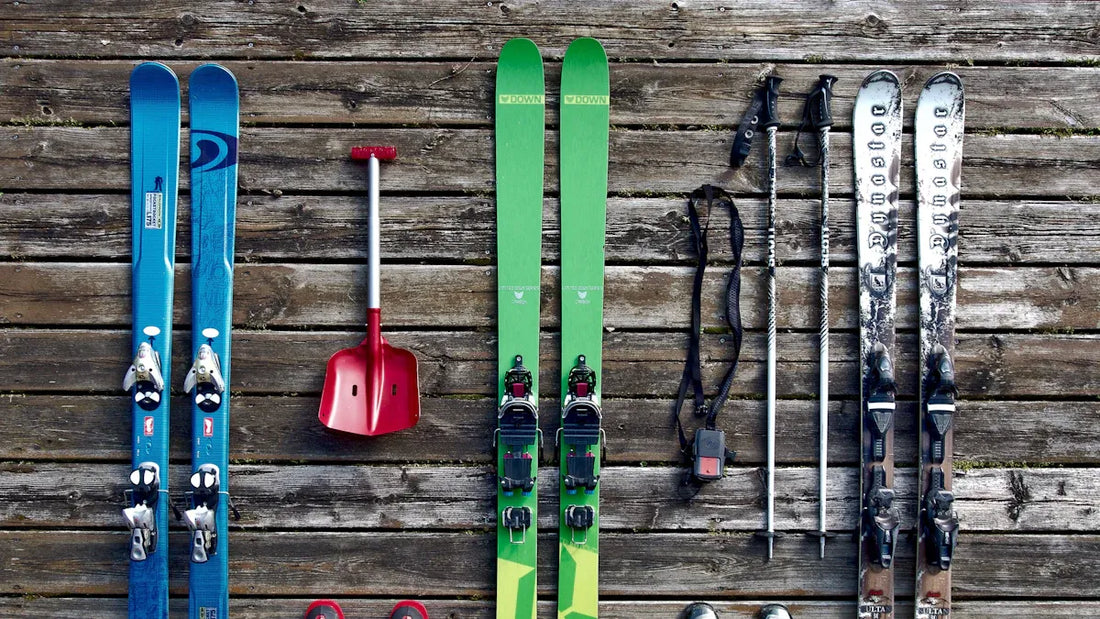 Baggy snowpants and ski gear laid out on wooden floor