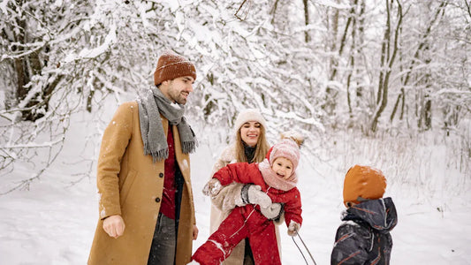 Family skiing outdoors, dressed in warm, cozy winter outfits for snow activities.