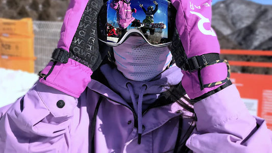 Woman in purple ski jacket and goggles on the slopes.