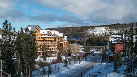 A luxury ski resort village with snow-covered mountains and pine trees