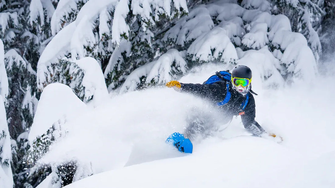Snowboarder in full gear carving through fresh snow