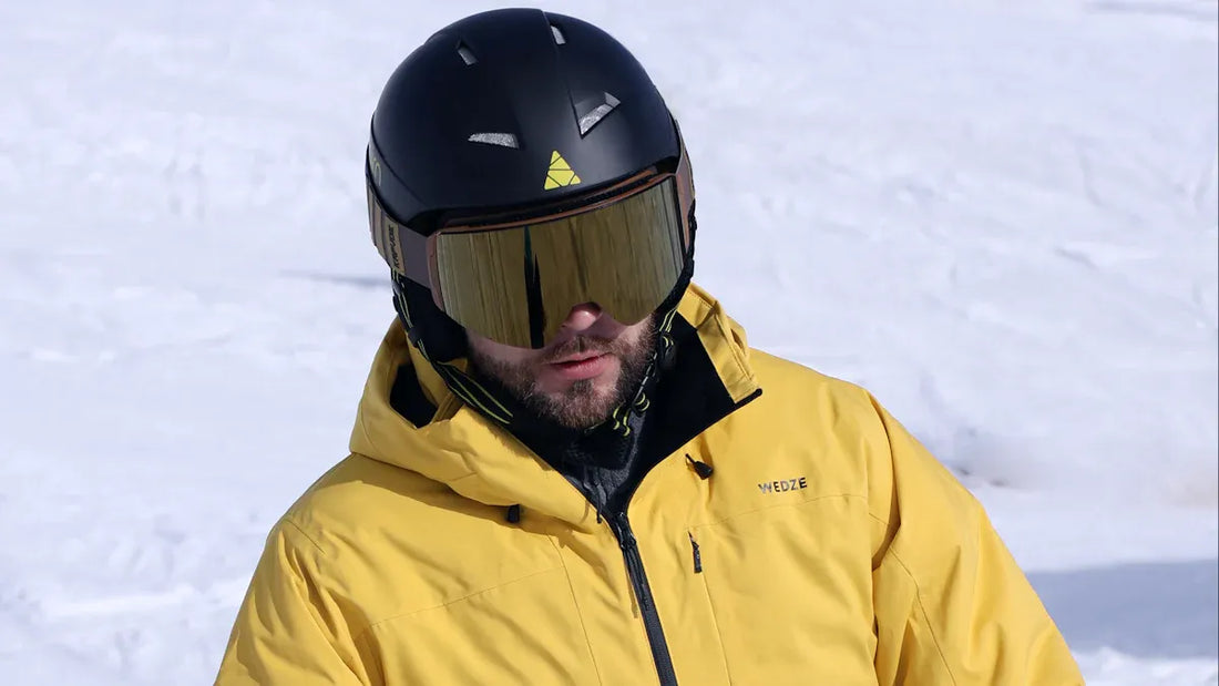 Mens yellow snowboarding jacket with black helmet and goggles.