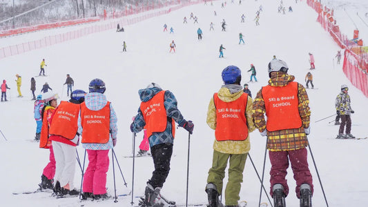 Group of children learning to ski with ski school gear.